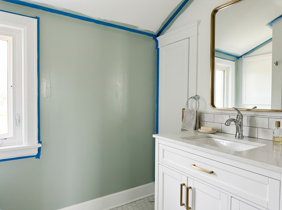 Freshly painted small bathroom with light walls, white trim, and a moisture-resistant ceiling finish