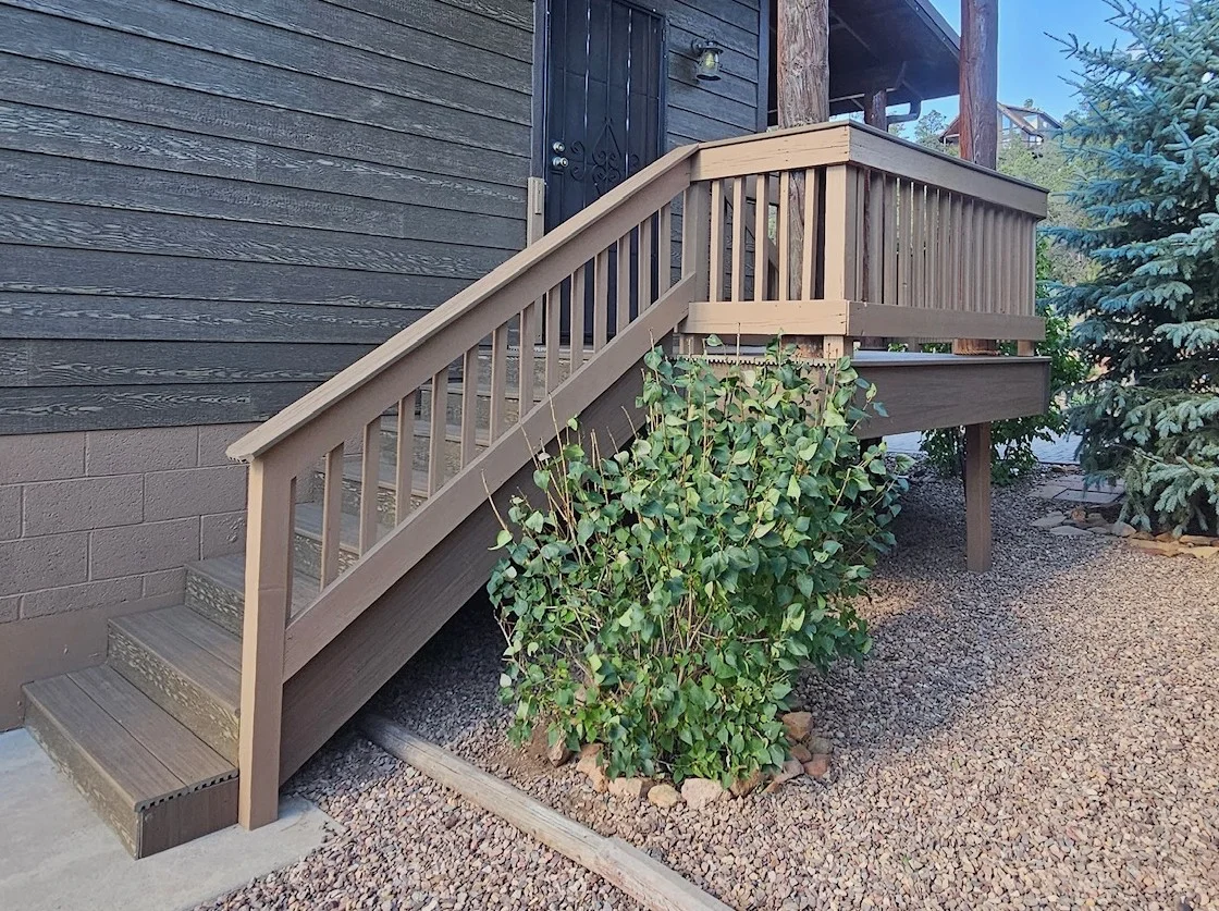 Stained composite deck with vertical spindle railings and integrated stairs