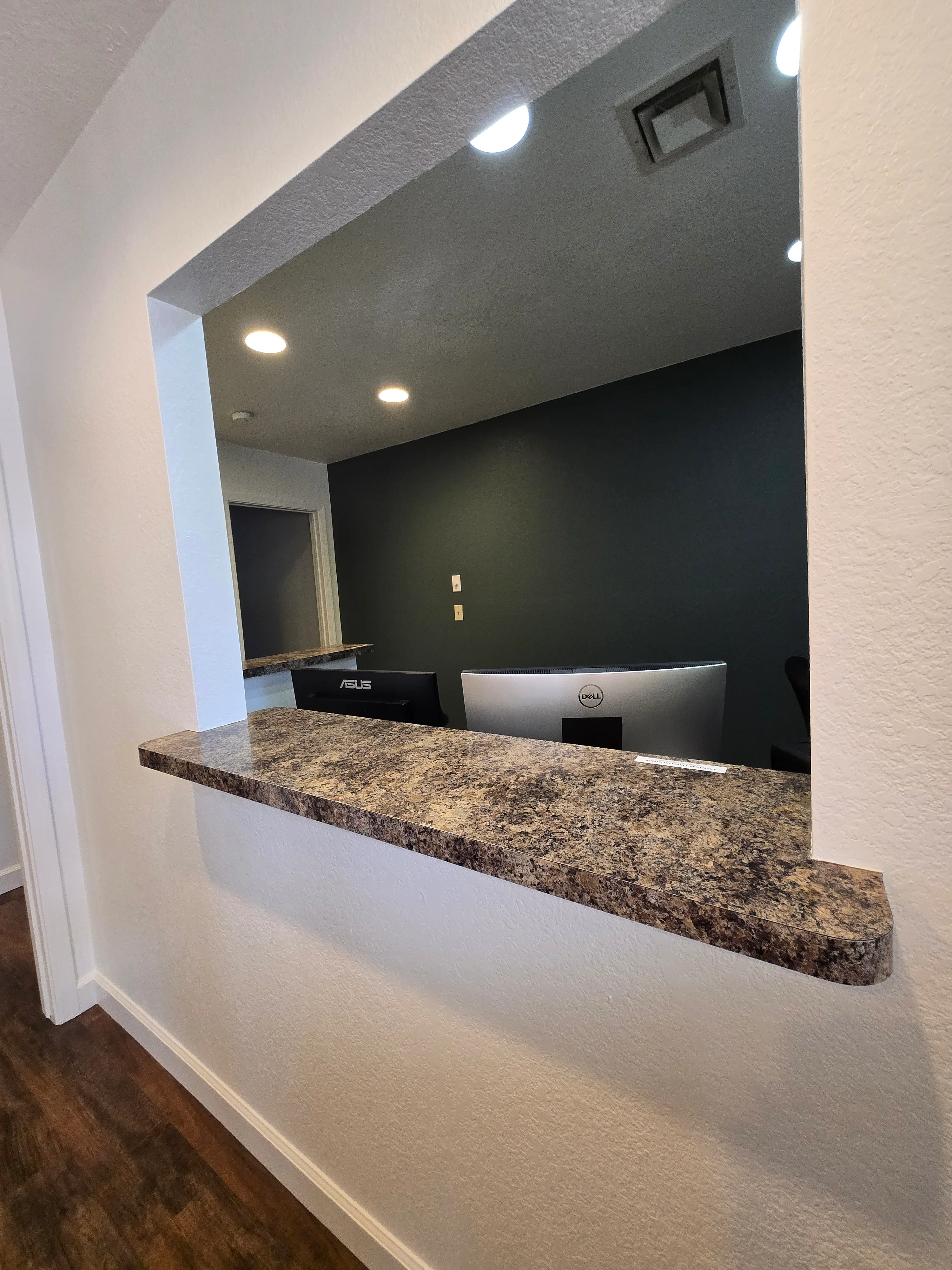 Charcoal accent wall with gray ceiling, recessed lighting, and white drywall in office nook