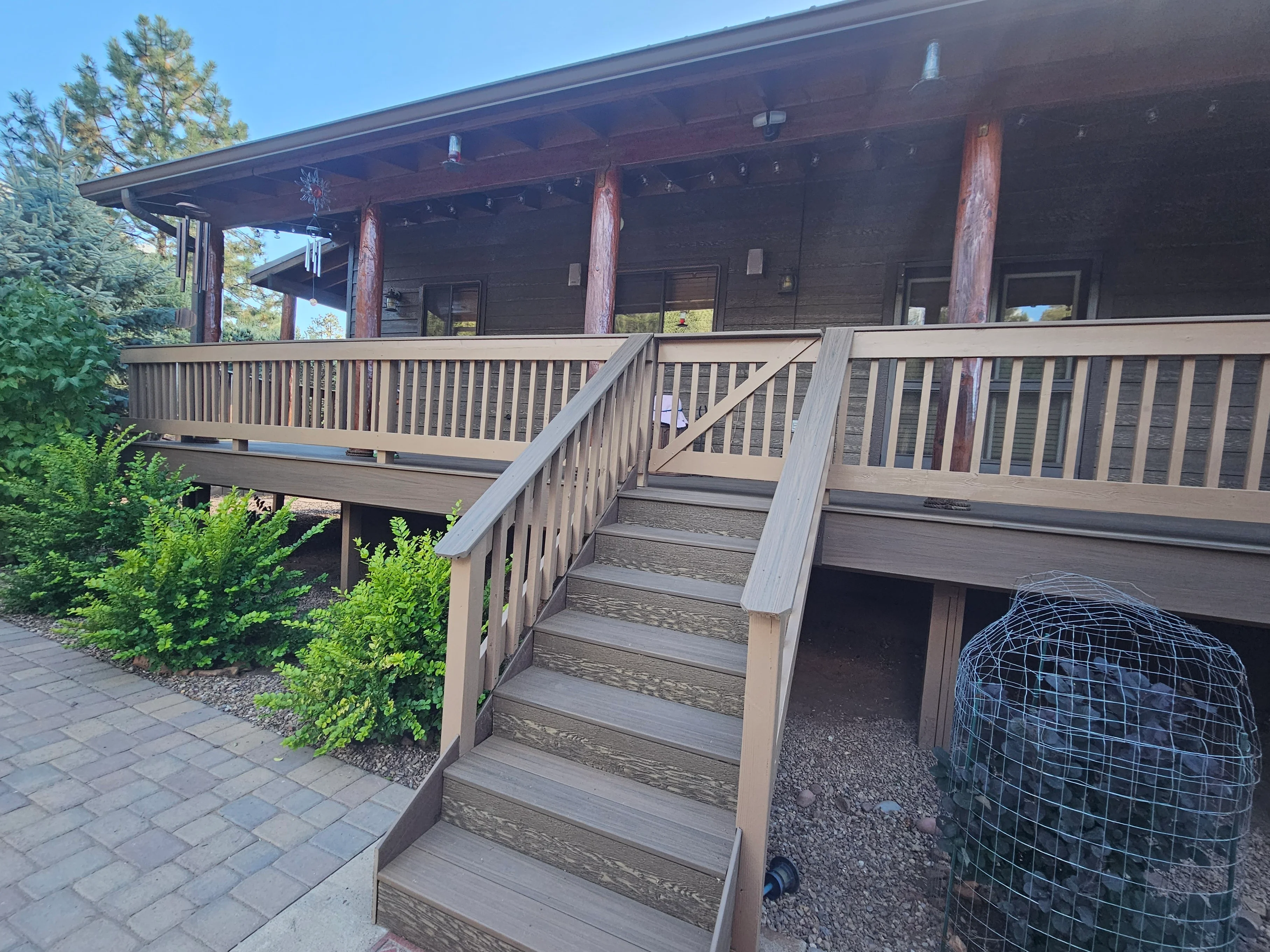 Gray-stained composite deck with matching railings, stairs, and vertical balusters on residential home