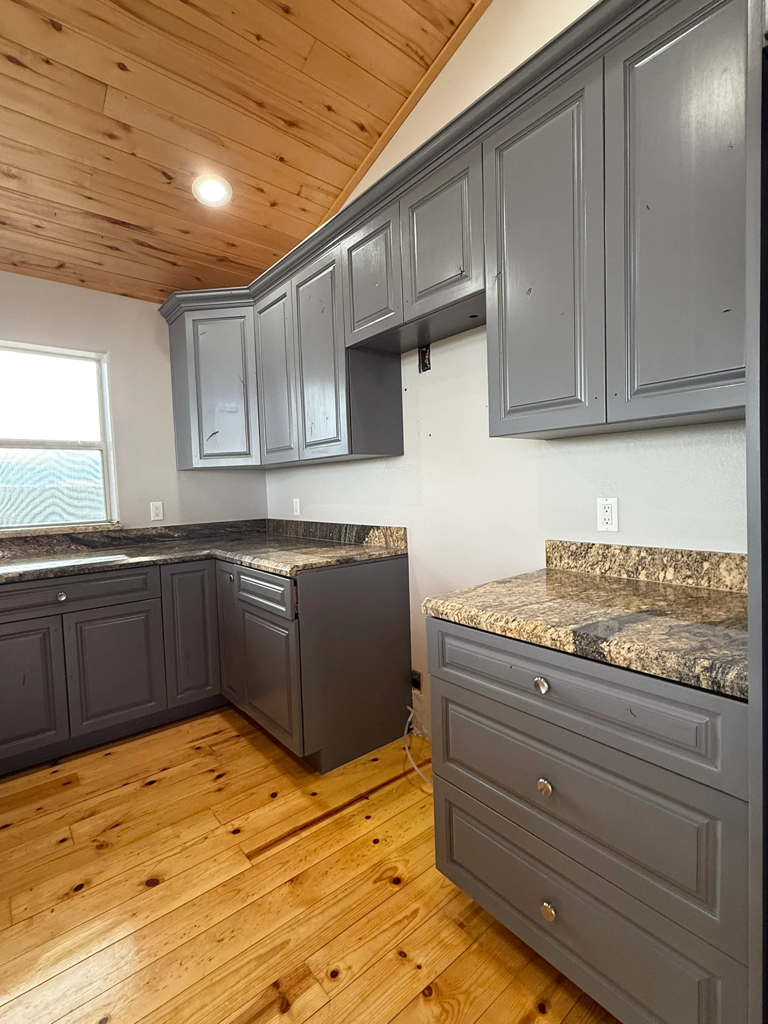 Two-tone painted kitchen cabinets in charcoal gray and dark espresso with granite countertops
